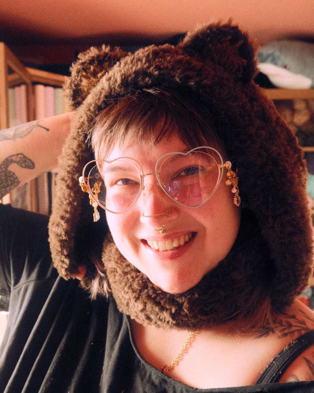 Person wearing a brown bear hat with ears indoors