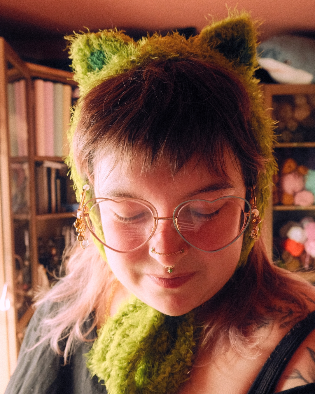 Person wearing headband style earmuff made of mossy yarn with cat ears