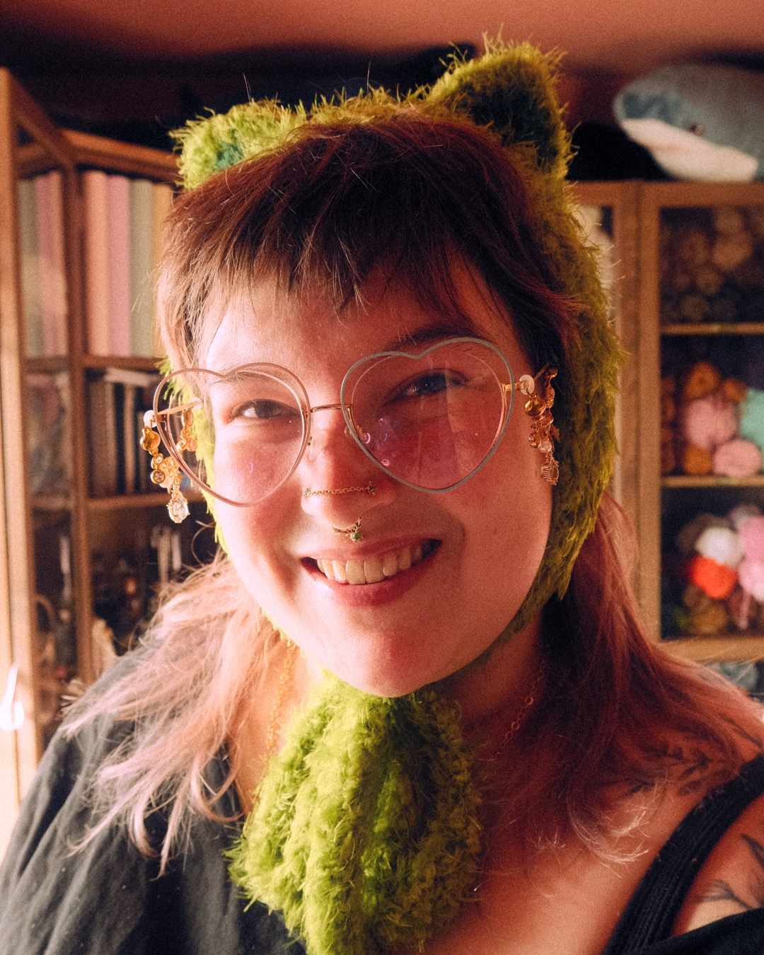 Person wearing a green crochet headband with animal ears indoors.