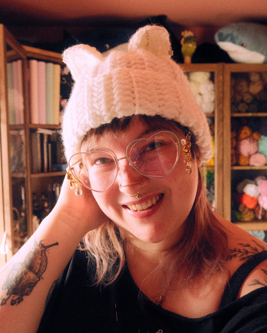 person wearing a white crochet hat with cat ears