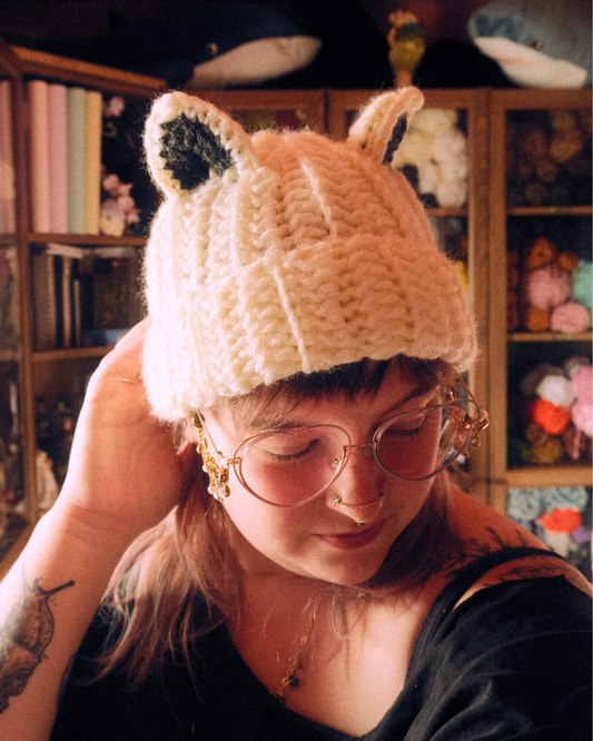 Person wearing a crochet beanie hat with animal ears