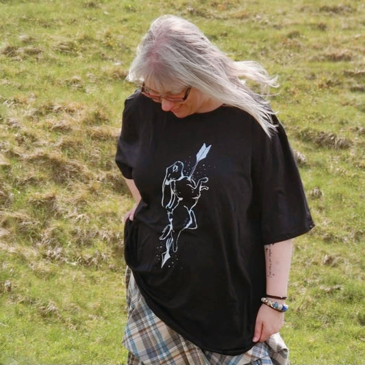 Model Lisa wears a black size 4xl oversized tshirt. The artwork is a white ink drawing of a hare with an arrow shot through it.